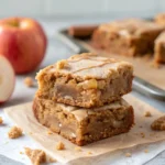Close-up of stacked apple cider blondies showing chewy crumb and thin glaze.