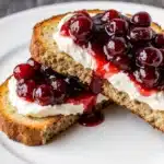 Close-up of cranberry brie crostini showing creamy cheese and cranberry topping.