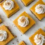 No-bake pumpkin cheesecake bars with whipped cream on top