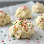 close-up of white chocolate haystacks coated in glossy white chocolate with red and green sprinkles