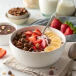 A large High Protein Loaded Cereal bowl filled with chocolate protein cereal, strawberries, and banana slices, served with chocolate protein milk.