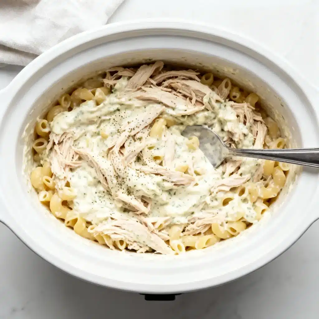 Creamy ranch chicken with noodles in white crockpot.