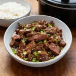 Juicy Slow Cooker Korean Beef strips made with flank steak and sesame seeds.