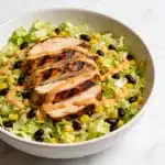 Finished High Protein BBQ Chicken Chopped Salad in a white bowl on a marble surface.