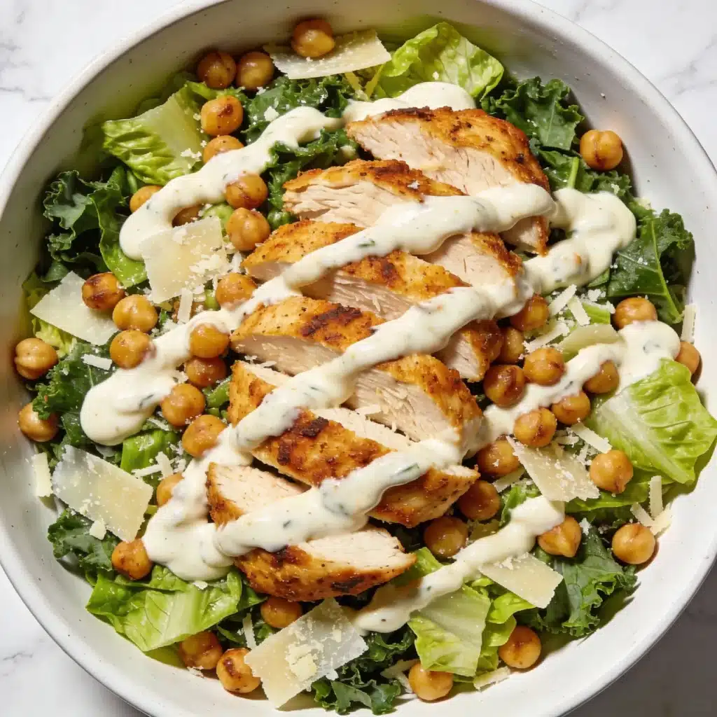 High protein chicken caesar salad with roasted chickpeas in a white bowl.