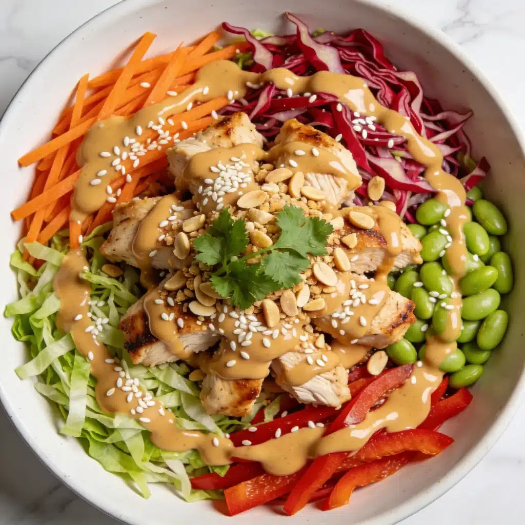 A vibrant Thai Peanut Chicken Salad in a white bowl with creamy peanut dressing.