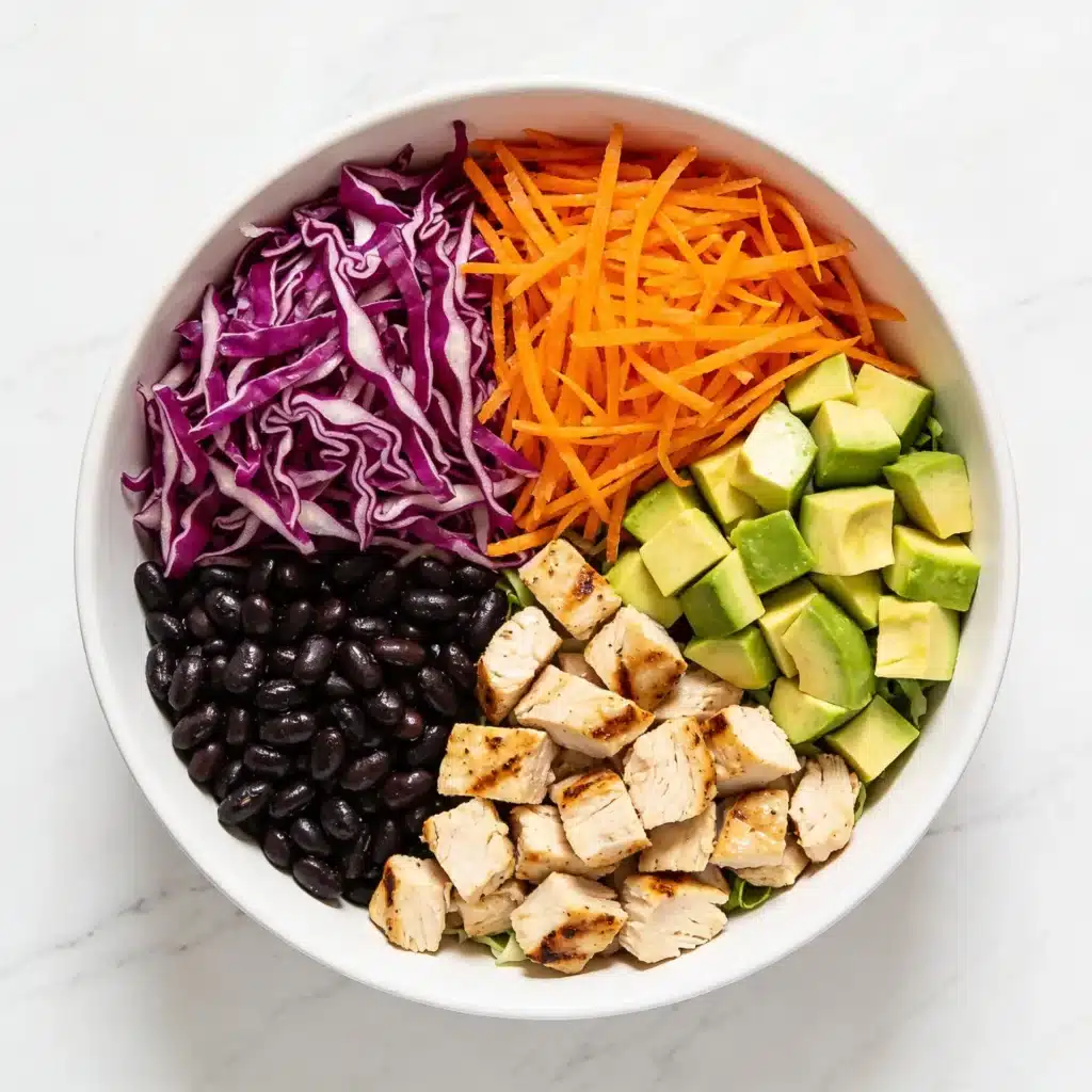 Fresh ingredients spread for a high protein thai chopped salad on a marble surface.