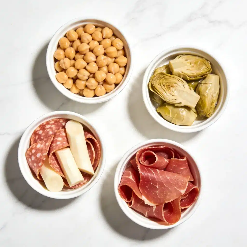 Fresh ingredients spread for a high protein mediterranean deli salad on a marble surface.