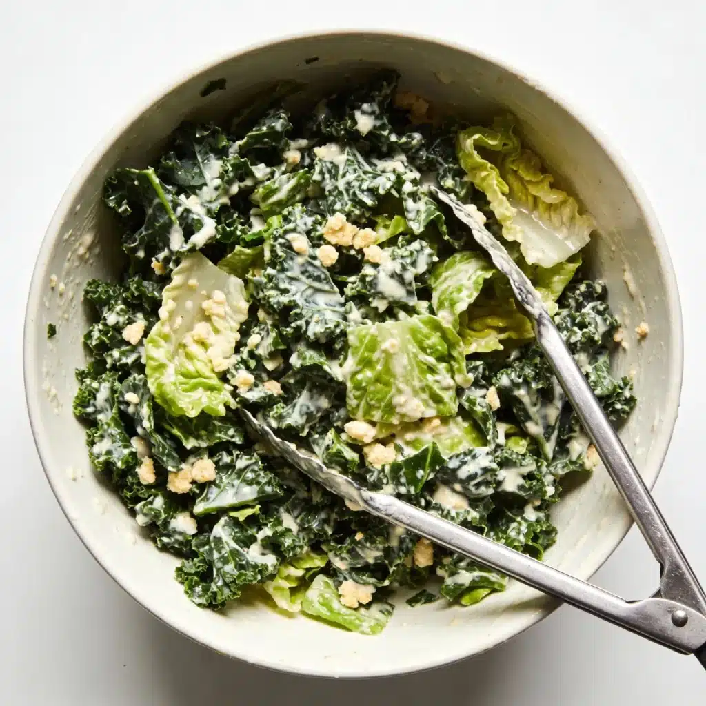 Chopped kale and romaine coated in creamy dressing in a bowl.