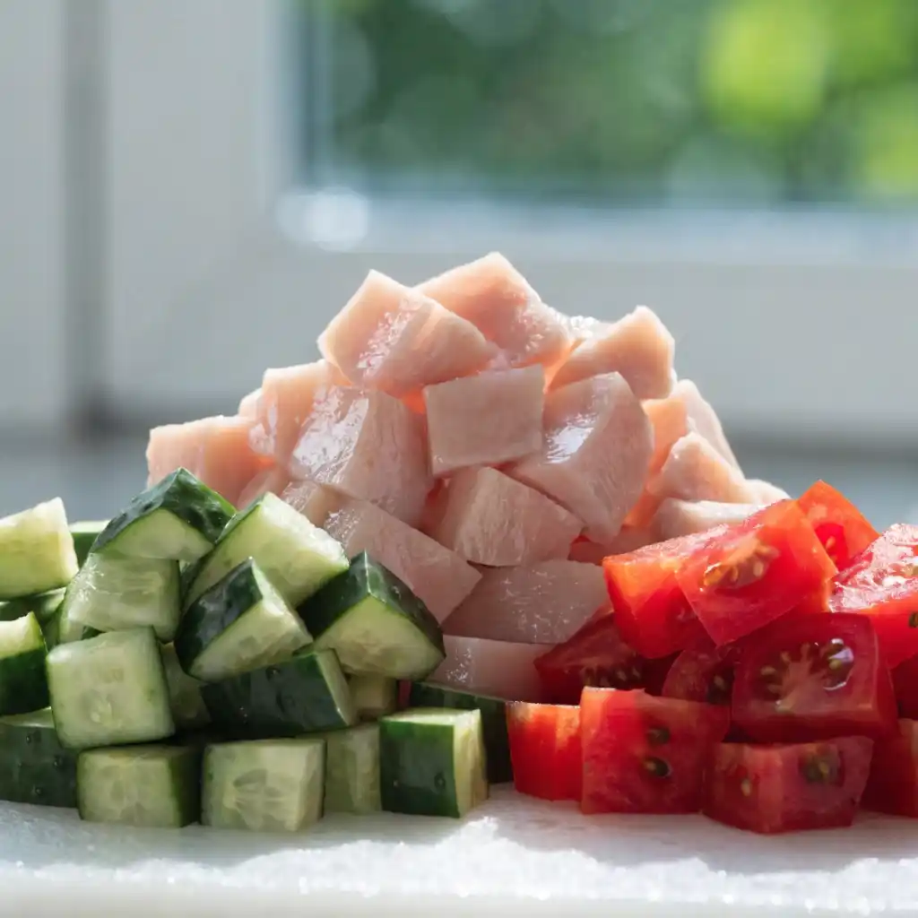 Diced chicken and cucumbers illustrating the uniform dice technique for a power bowl.
