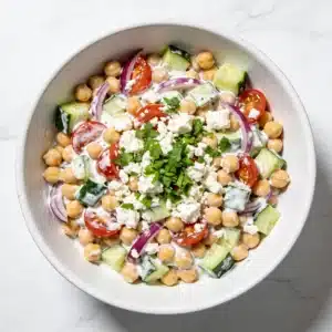High protein mediterranean chickpea salad in a large white bowl.