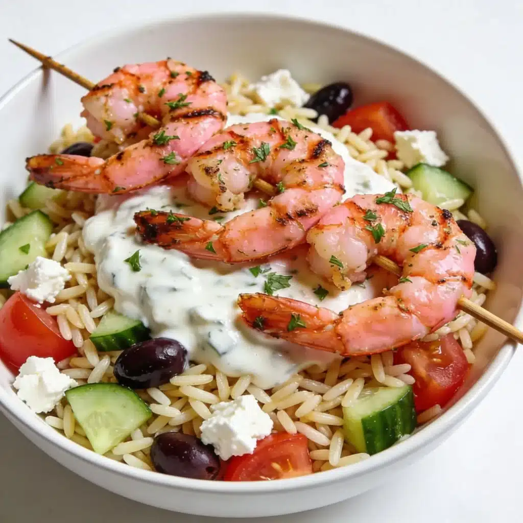 Mediterranean Greek orzo salad topped with grilled shrimp skewers.