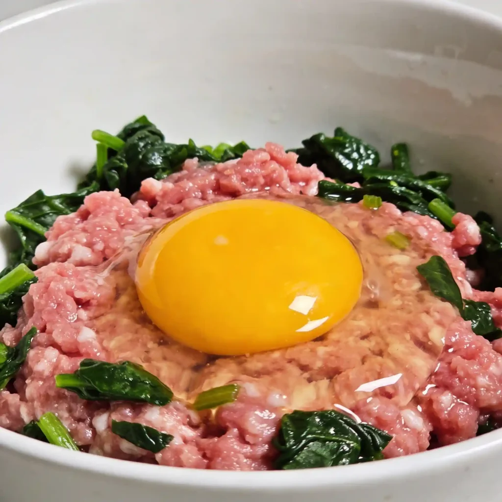 Adding a fresh egg to ground turkey meatball mixture as a healthy binder.