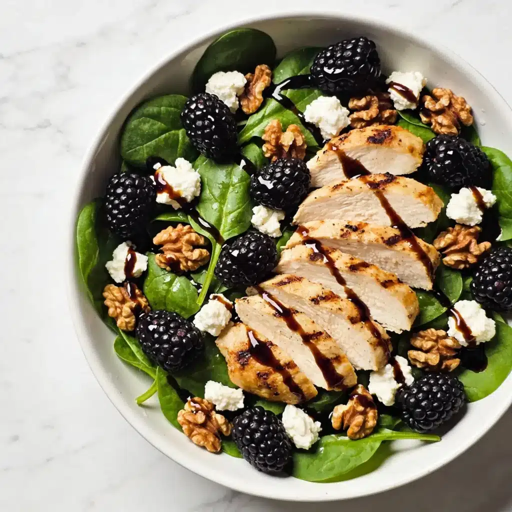 A vibrant Blackberry and Goat Cheese Salad with grilled chicken and fresh spinach.