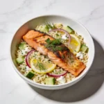 A vibrant Mediterranean salmon orzo salad with crispy salmon and fresh herbs.