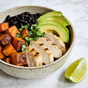 A vibrant roasted sweet potato black bean bowl with chicken and avocado.