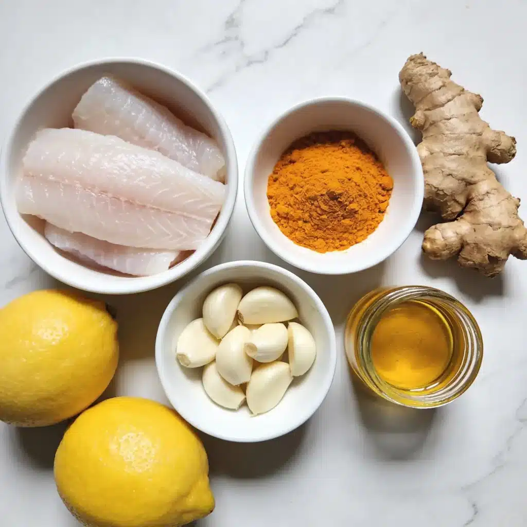 Raw ingredients for a turmeric ginger fish skillet spread on a white marble surface.