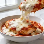 A close-up of melted mozzarella cheese over a warm cottage cheese chicken parmesan bowl.
