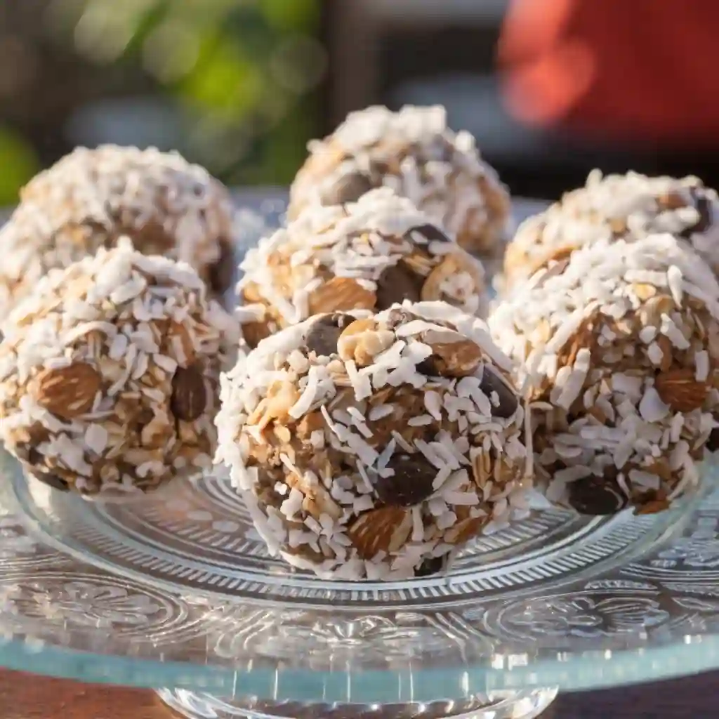 A large plate of gluten free energy bites showing their coconut and almond texture.