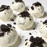 Cookies and cream protein balls resting neatly on a large, sleek white ceramic platter.