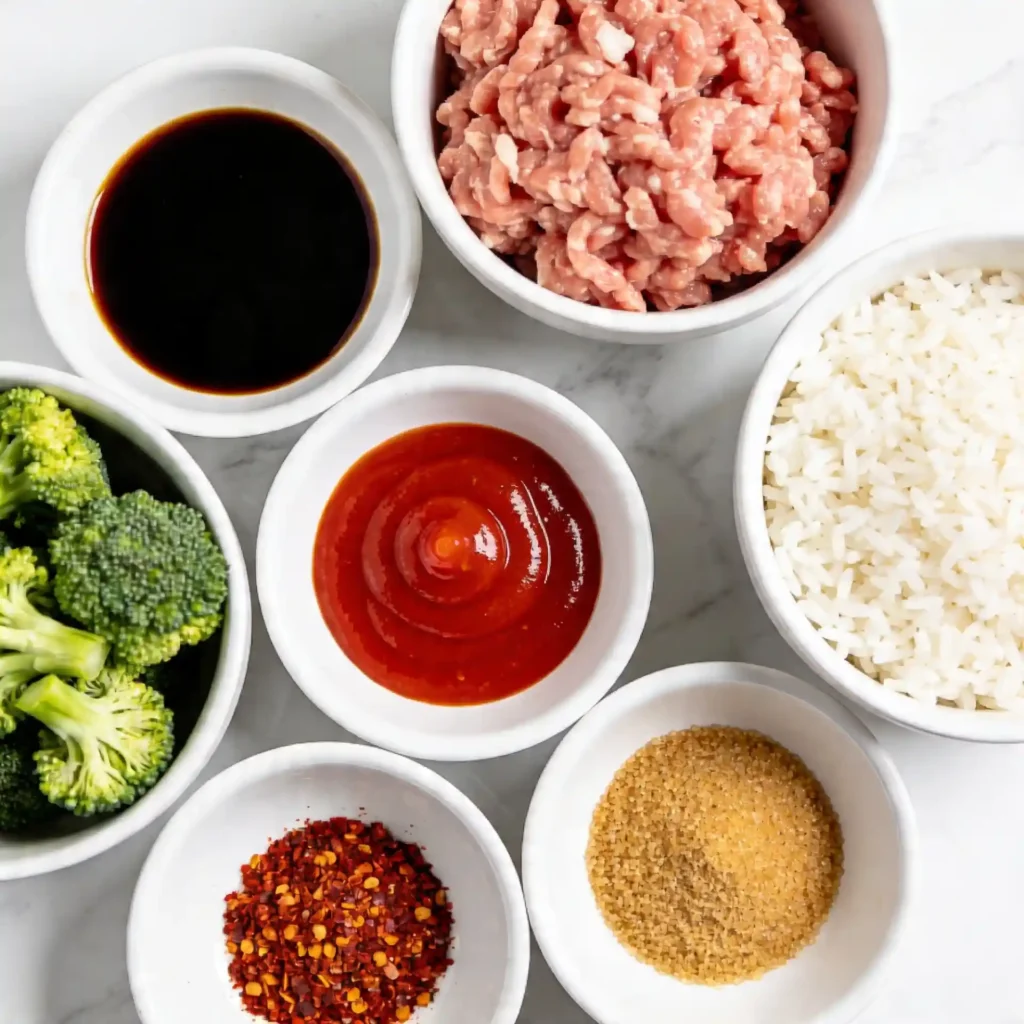 Fresh ingredients neatly arranged in small white bowls to make sweet and spicy ground chicken.